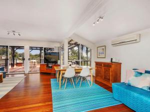 a living room with a table and a blue couch at Spacious Beachside Townhouse with Large Balcony in Terrigal