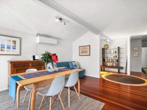 a living room with a table and chairs and a couch at Spacious Beachside Townhouse with Large Balcony in Terrigal