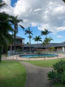 una casa con piscina y palmeras en Oxley Motor Inn, en Brisbane