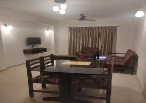 阿伯來的住宿－Areia De Goa - Sunset By Leela Homes，客厅配有桌椅和沙发