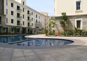 a swimming pool in front of a building at Areia De Goa - Sunset By Leela Homes in Arpora