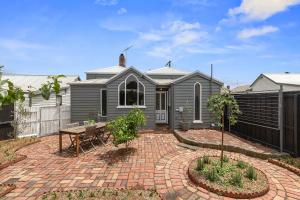 een huis met een bakstenen patio ervoor bij Central Geelong West Cottage in Geelong West