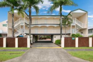 un edificio con palmeras delante en Cairns City Sheridan Motel, en Cairns