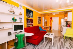 a living room with a red couch and a tv at Kakadu Hostel in Khabarovsk
