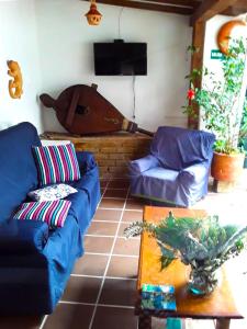 una sala de estar con 2 sofás azules y una mesa. en Hostal Rana, en Villa de Leyva