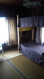 a bedroom with a bunk bed and a window at raibrasil guest house in Sanuki