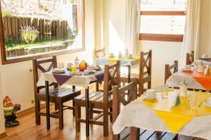 un comedor con mesas y sillas y una ventana en Hostería Los Gnomos en El Calafate