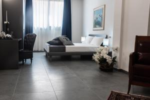 L'Essenza Hotel في أولبيا: غرفة نوم بسرير وطاولة وكرسي