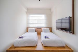 two twin beds in a room with a tv at Park Hotel Kyoto in Kyoto