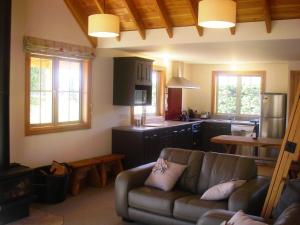 a living room with a couch and a kitchen at Lexi's Lodge in Lake Tekapo