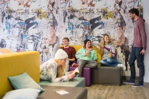 a group of people sitting on a couch in a room at Oberstdorf Hostel in Oberstdorf