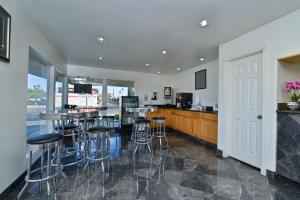 a kitchen with a bar with stools in it at Crown Hotel in El Centro