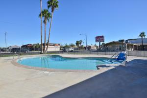 una piscina in un parco con palme di Crown Motel a El Centro