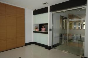 a woman is standing in the window of a building at Rangsit Apartment II in Ban Talat Rangsit