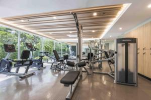 a gym with several treadmills and exercise equipment at Maitria Hotel Rama 9 Bangkok - A Chatrium Collection in Bangkok