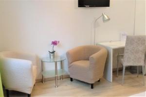 a room with a chair and a table with a lamp at Pension Bunz in Kelsterbach