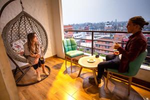 a man and a woman sitting in chairs in a room at Arushi Boutique Hotel in Kathmandu