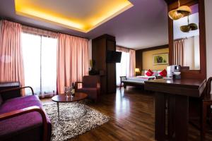 uma sala de estar com um sofá e uma mesa num quarto em Salana Boutique Hotel em Vientiane