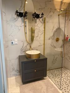 W łazience znajduje się umywalka i lustro. w obiekcie Apartament Złoty w mieście Zblewo