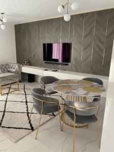 salon ze stołem, krzesłami i telewizorem w obiekcie Apartament Złoty w mieście Zblewo