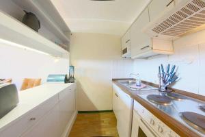 una pequeña cocina con armarios blancos y fregadero en Apartment 581 en Hohegeiß