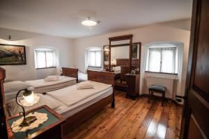 a bedroom with two beds and a bathroom at Hotel Dvor Jezersek Brnik in Cerklje na Gorenjskem