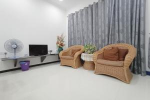two wicker chairs and a television in a living room at OYO Home 90203 Emma Sukma Homestay in Kuching