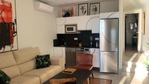 a living room with a couch and a stainless steel refrigerator at ON VILLAGE DELUXE in Matalascañas