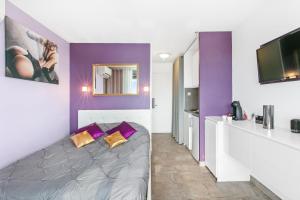 um quarto roxo e branco com uma cama e uma cozinha em Village Naturiste R4N - Le Candi Port Venus Panoramic View em Cap d'Agde