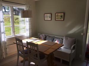 a dining room with a table and a couch at Trädgårdsstugan på Malingsbo herrgård in Malingsbo