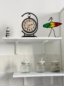 a shelf with a clock and a bird on it at Corso Italia 4 in Bordighera