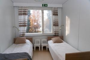 Wilderness Estate Pukari, Kuusamon Erämajoitus في كوسامو: سريرين في غرفة مع نافذة