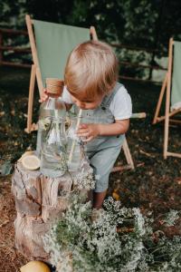 a young boy playing with a jar of flowers at Apartamenty Pod Lipami in Szczawnica