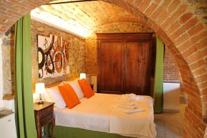 una camera con un letto in un muro di mattoni di I Voltoni di Corsignano a Siena