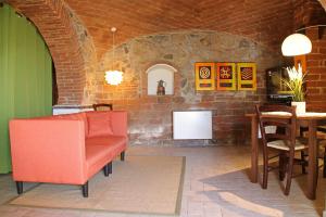 una stanza con tavolo, sedie e un muro di mattoni di I Voltoni di Corsignano a Siena