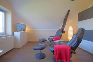 a waiting room with four chairs and a television at Gaestehaus Dorum 05 in Dorum