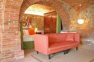 a red couch in a room with a bedroom at I Voltoni di Corsignano in Siena