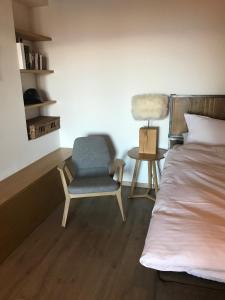 um quarto com uma cama, uma cadeira e uma mesa em Telemark Guesthouse em Nendaz
