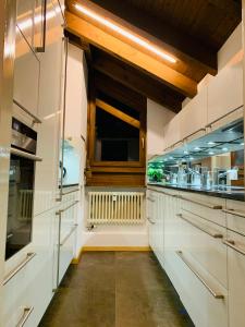 eine Küche mit weißen Schränken und einem Fenster in der Unterkunft Breathtaking Waterfall Apartment nr 3 in Lauterbrunnen