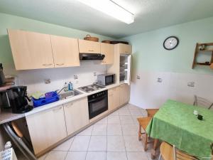 a kitchen with white cabinets and a green table at Ferienhaus Zeus / Seebad Ückeritz / Insel Usedom in Ueckeritz