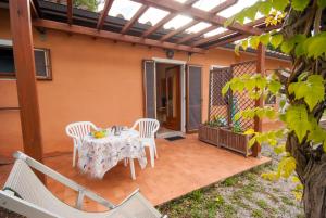 une terrasse avec une table et des chaises. dans l'établissement Residence Le Grazie Est, à Capoliveri