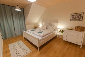 a bedroom with a white bed and a dresser at Chalet Pølarka in Demanovska Dolina