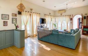 a living room with a couch and some windows at Casa Do Amor by VEO - Part of StayVista in Sangolda