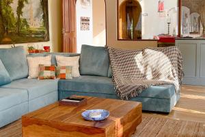 a living room with a blue couch and a coffee table at Casa Do Amor by VEO - Part of StayVista in Sangolda
