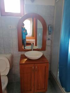 a man taking a picture of a bathroom with a sink at Park Vendégház in Herend +30 photos