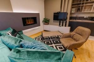 a living room with a couch and chairs and a tv at NAR Royalton Accommodation in Niš