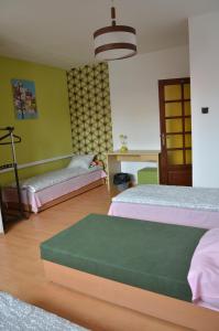 1 dormitorio con 2 camas y pared verde en Apartament Tolek, en Varsovia
