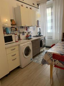 a kitchen with a washing machine and a table at CASA IVO in Genoa