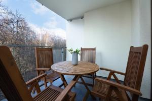 a wooden table and chairs on a balcony at Apartamenty Osiedle Polanki by Renters in Kołobrzeg