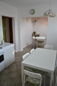 eine Küche mit einem weißen Tisch, Stühlen und einem Tisch in der Unterkunft Apartament Tolek in Warschau